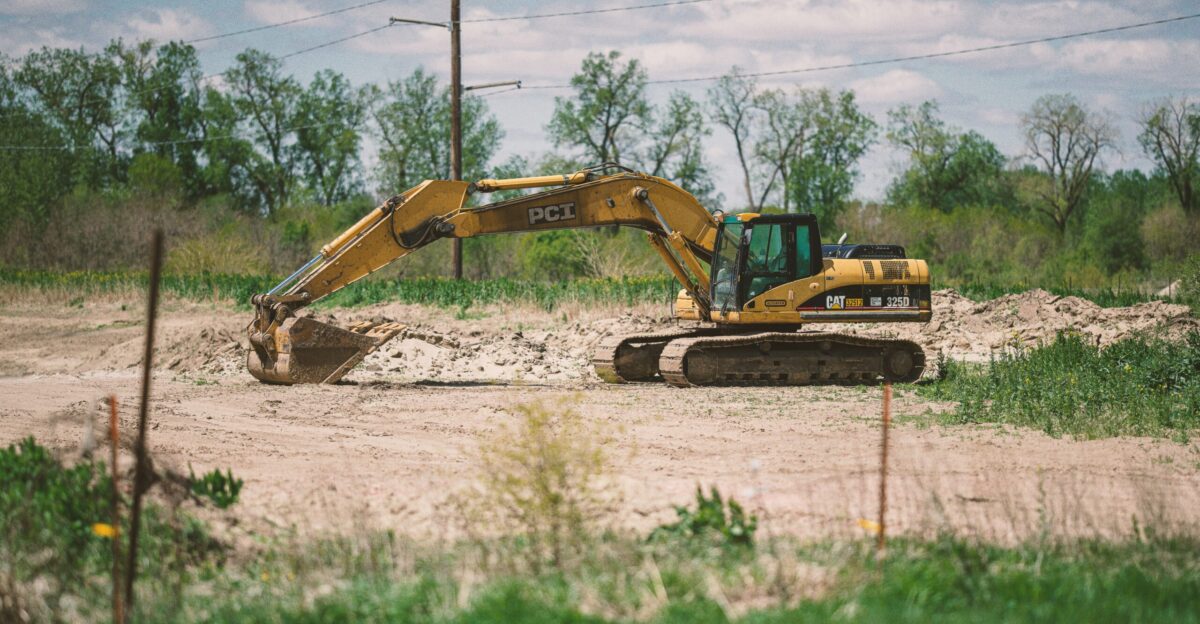 yellow and black excavator on brown field during daytime