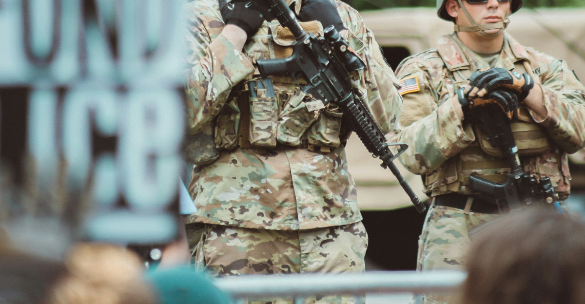 man in brown and black camouflage uniform holding rifle