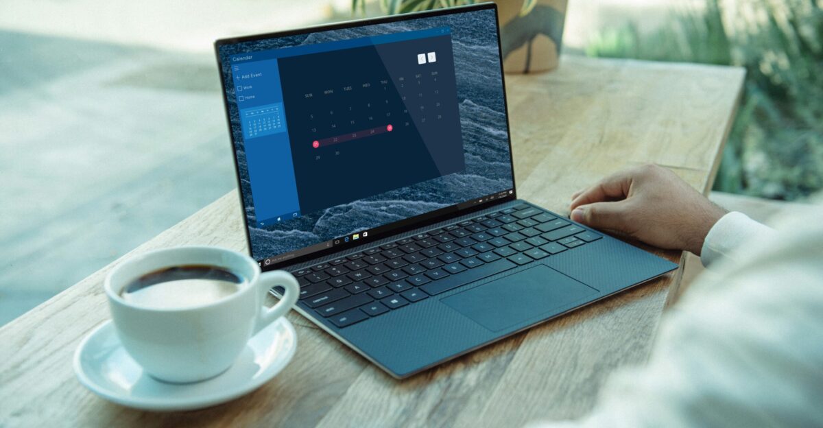person using black laptop computer on brown wooden table