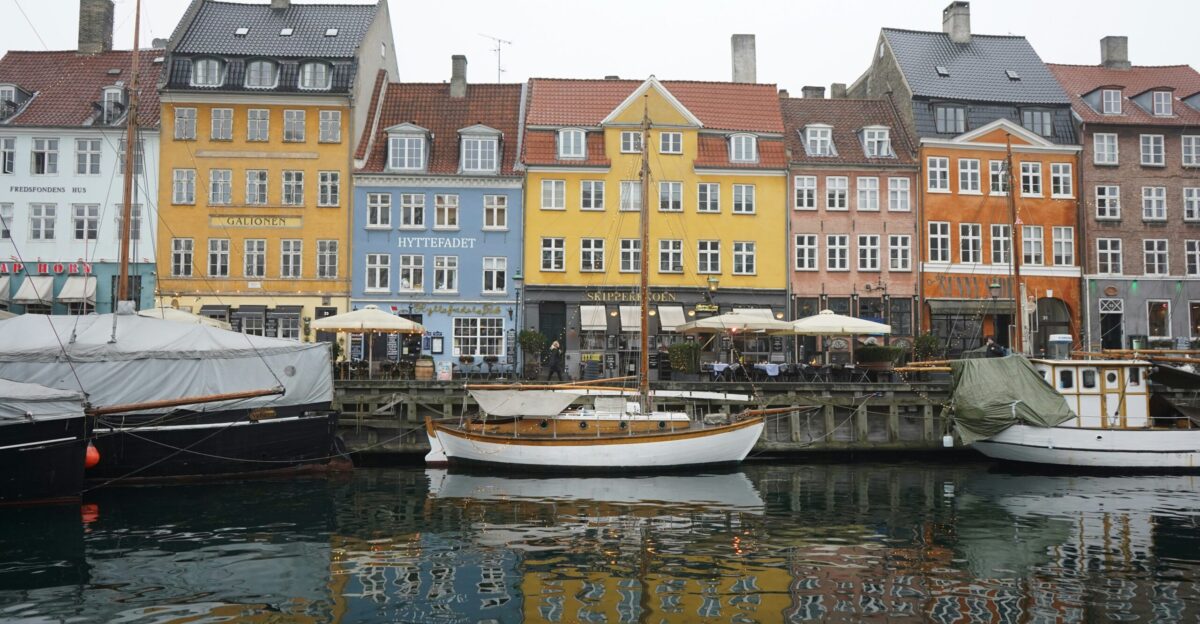 white boat on water near concrete buildings during daytime