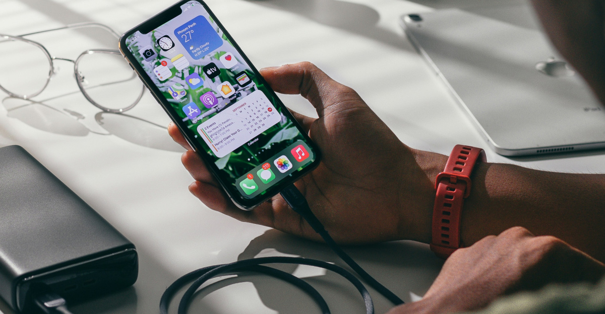 person holding black smartphone on white textile