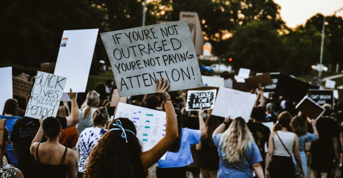 people holding white and black signage during daytime