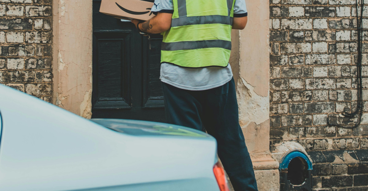 man in green and yellow striped shirt holding black smartphone