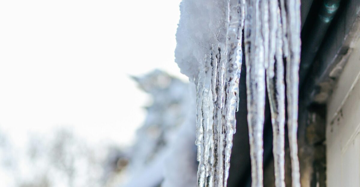 white snow on black wooden fence