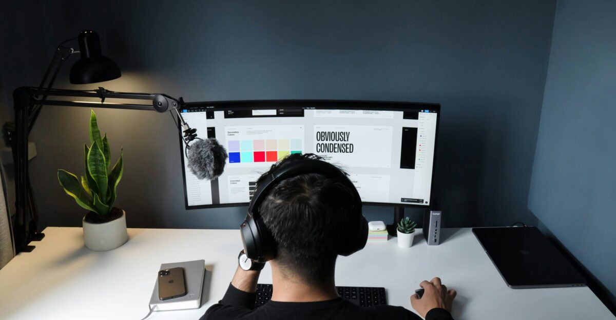 man in black shirt sitting in front of computer
