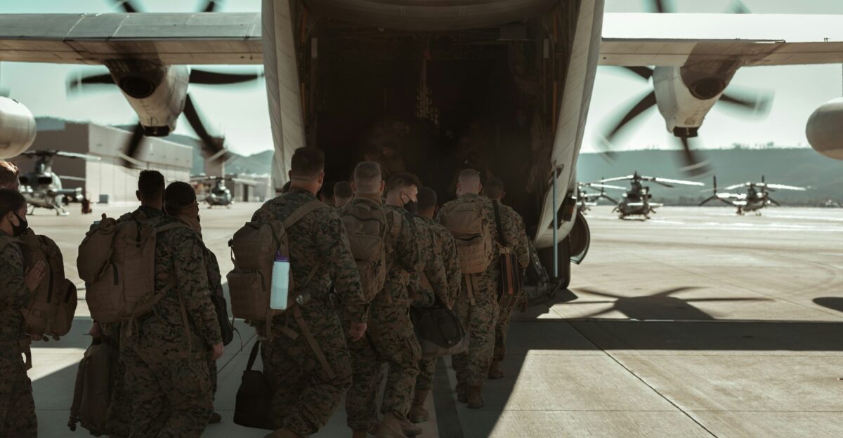 group of men in camouflage uniform standing near white airplane
