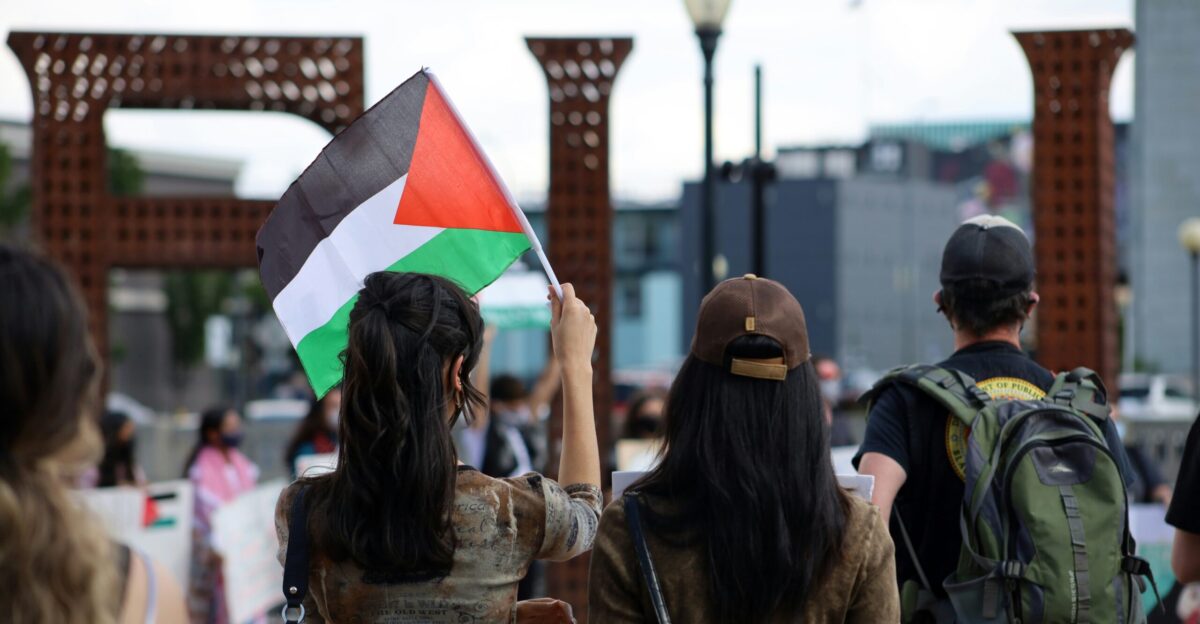 woman in brown jacket holding flag