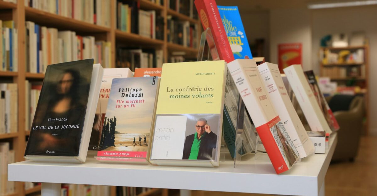 assorted books on white wooden shelf
