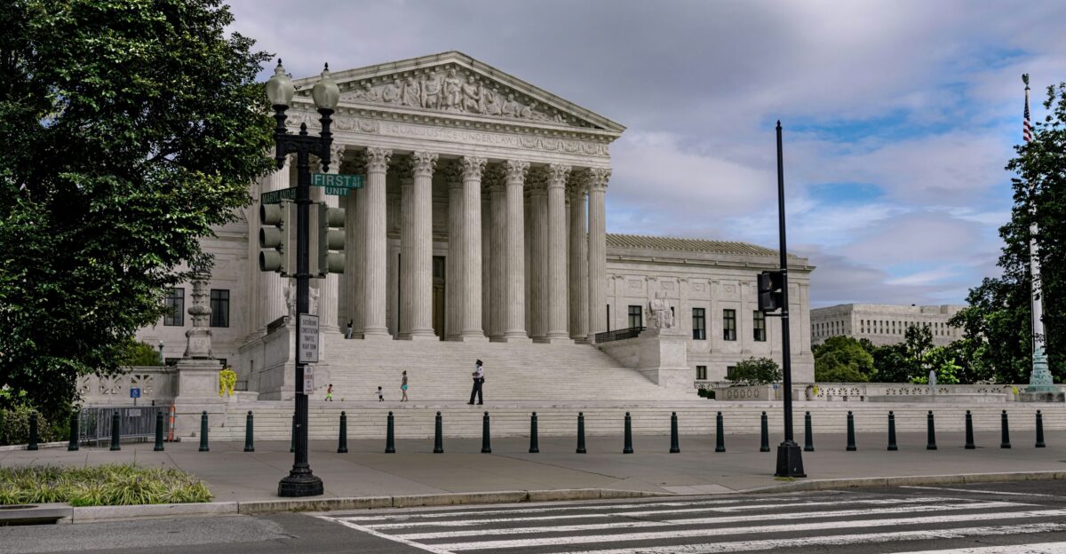 people walking on gray concrete pathway near white concrete building during daytime
