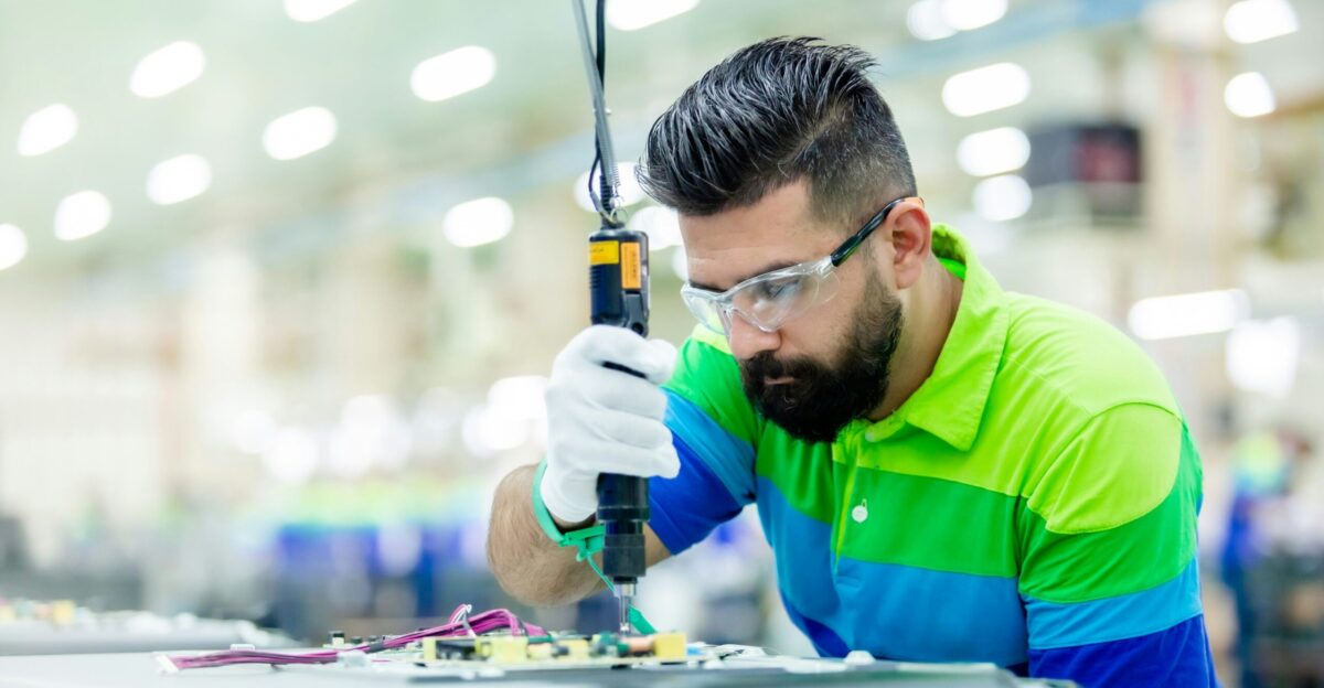 a man in a factory working on a piece of equipment