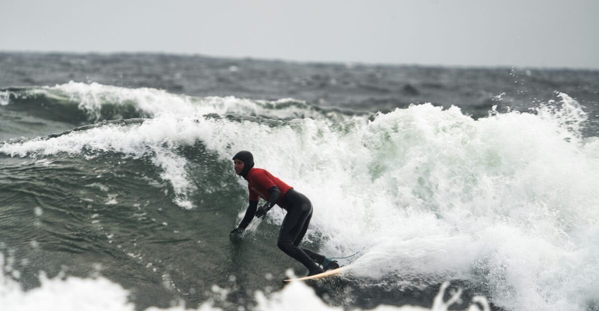 a man riding a wave on top of a surfboard