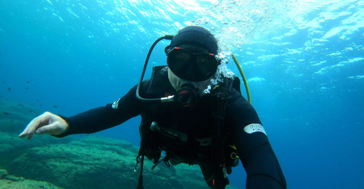 a man in a diving suit is holding out his hand