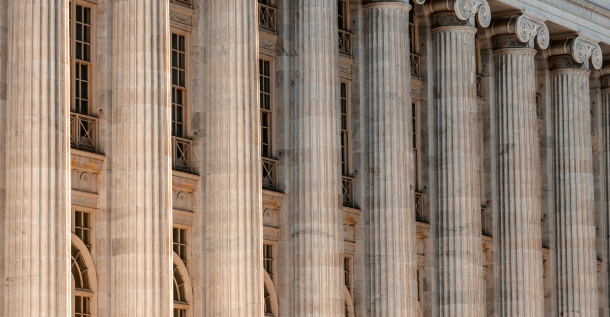 a large building with columns and a clock on the front of it