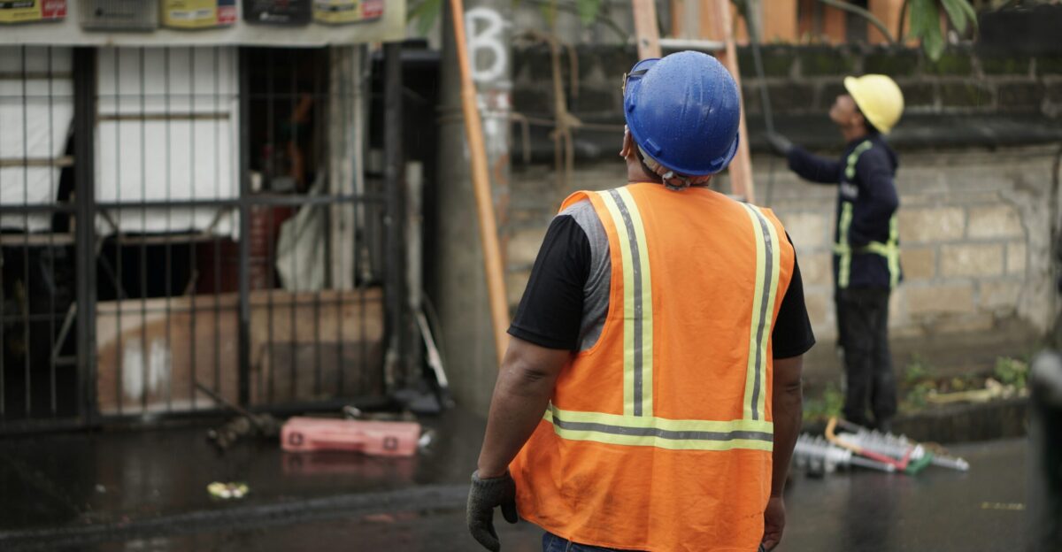 a man in an orange vest and a man in a blue helmet