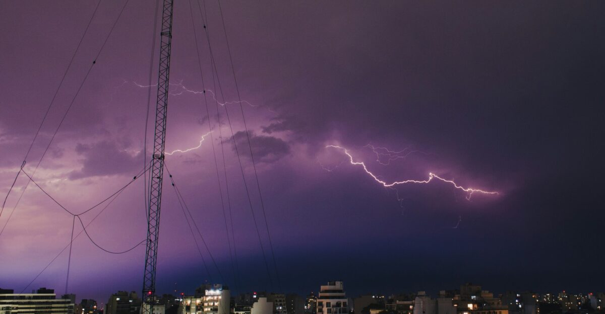 a lightning storm is seen over a city at night
