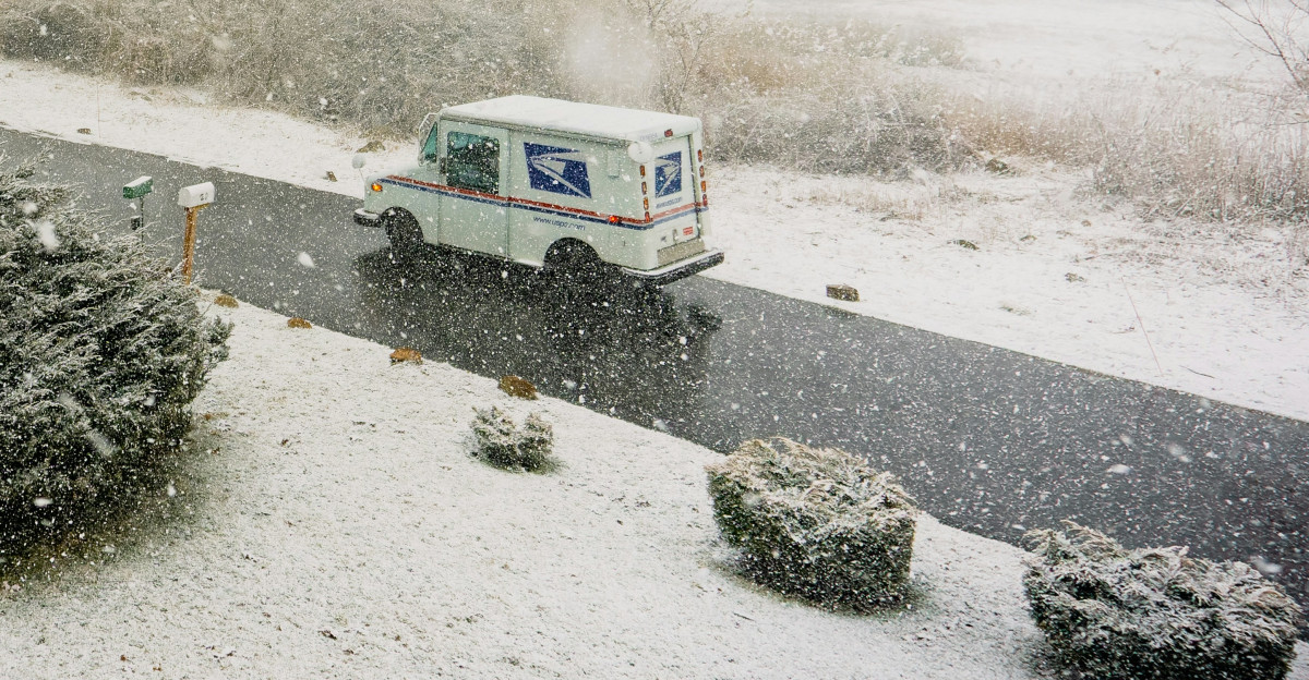 a white truck driving down a snow covered road