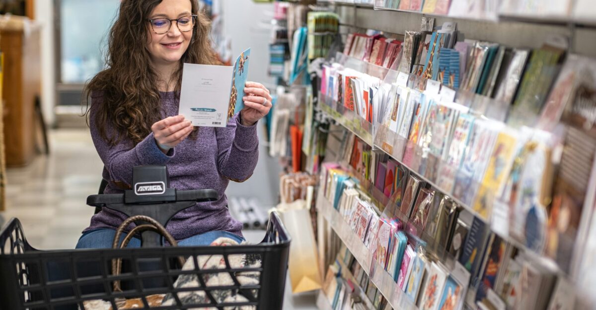 a woman sitting in a shopping cart holding a piece of paper