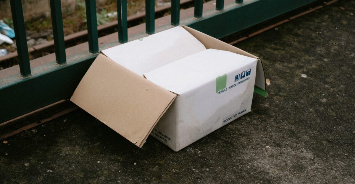 a box sitting on the ground next to a fence