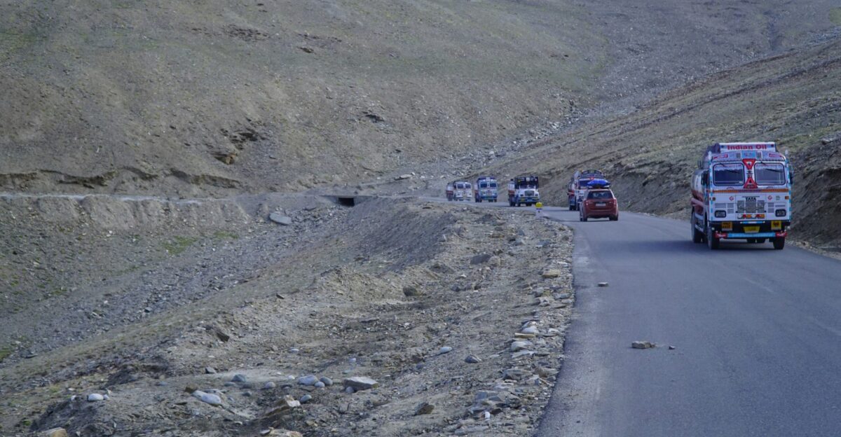 a group of trucks driving down a mountain road