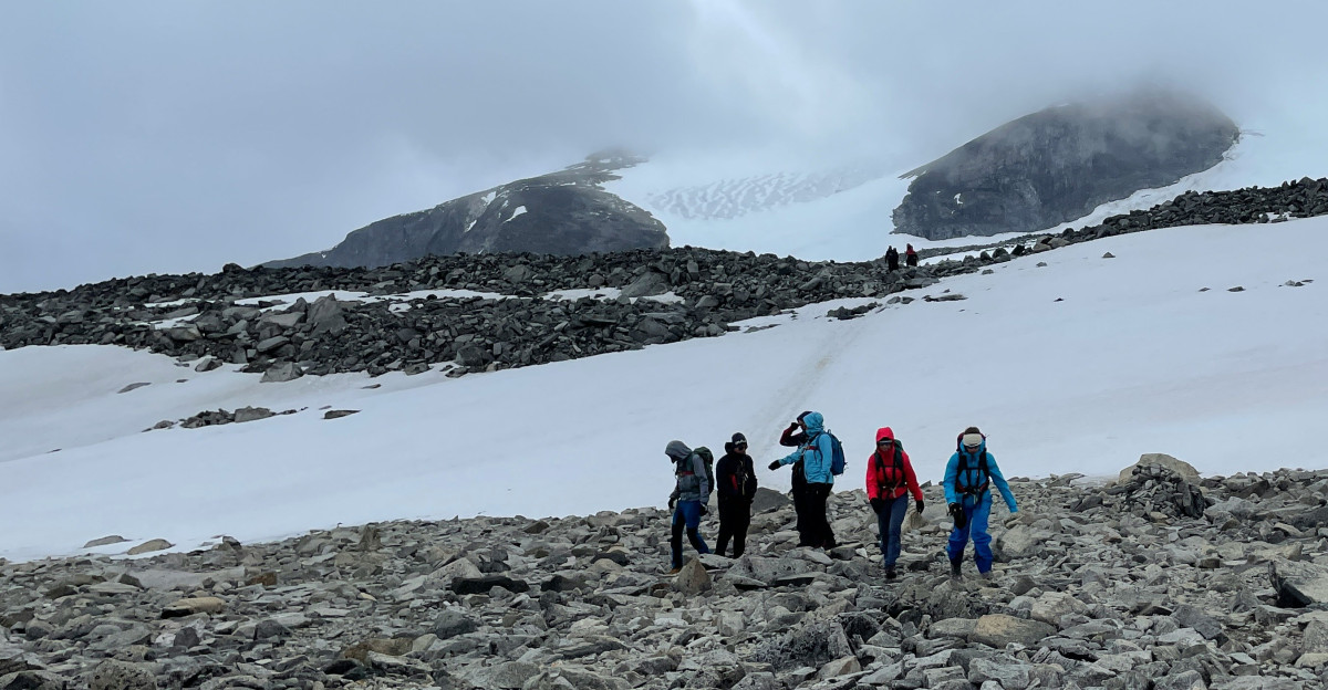 a group of people walking on a rocky beach