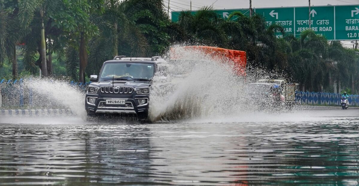 a car driving down a street next to water