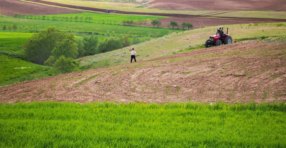 a person standing on a dirt road with a tractor on it