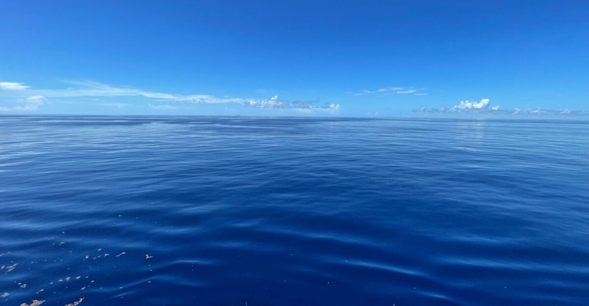 a body of water with a blue sky and clouds