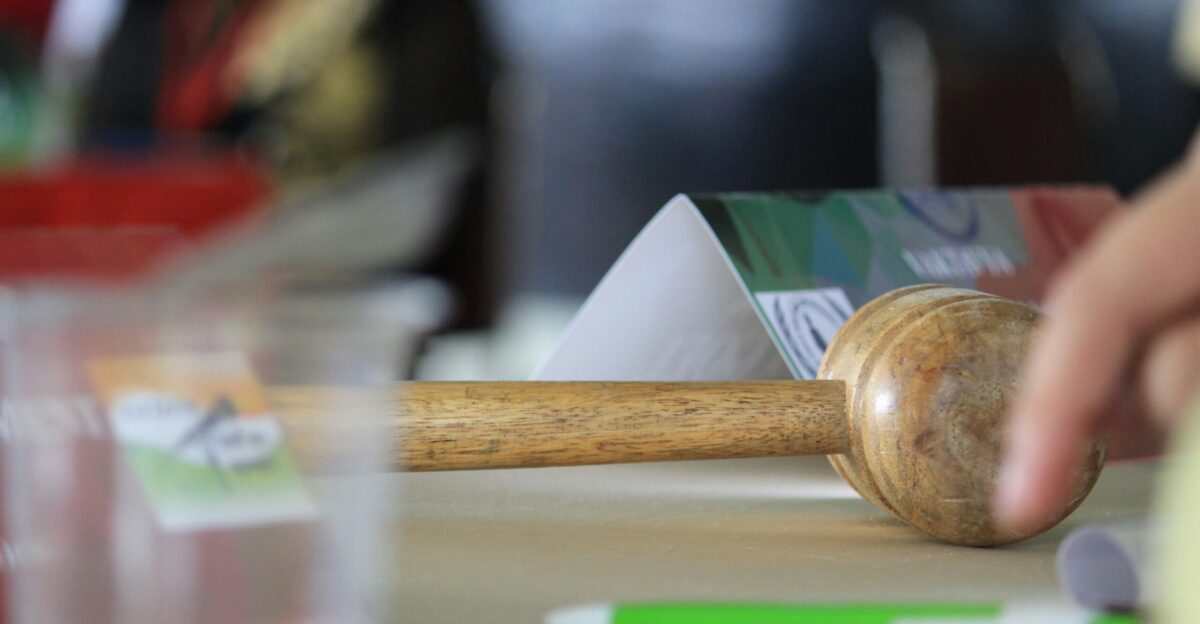 a hand holding a wooden block