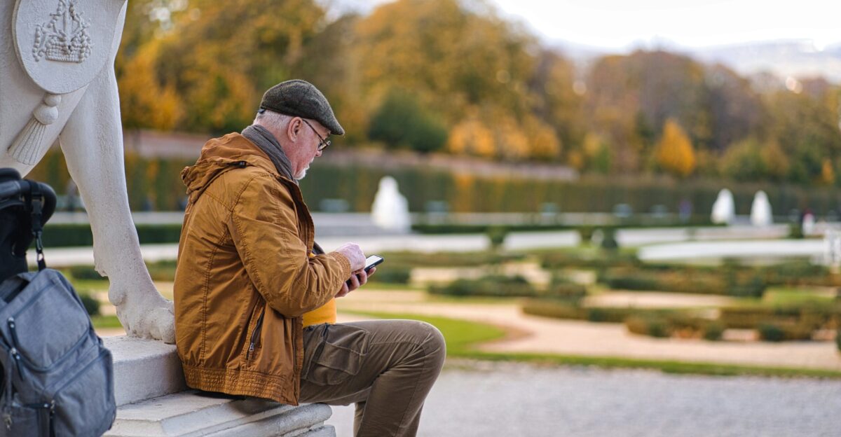 a man sitting on a bench looking at his phone