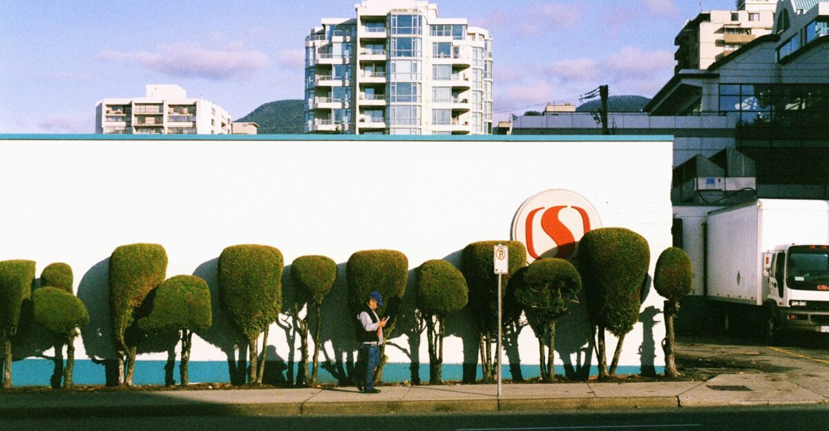 a man sitting on a bench in front of a wall