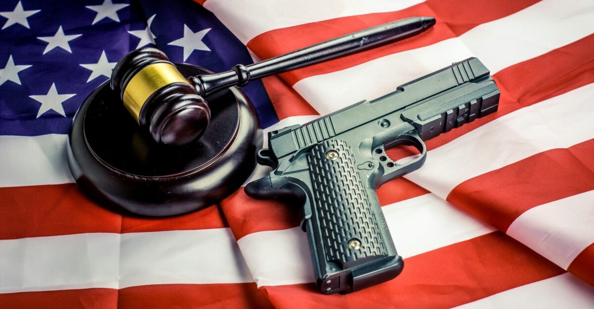 a gun a judge s hammer and an american flag
