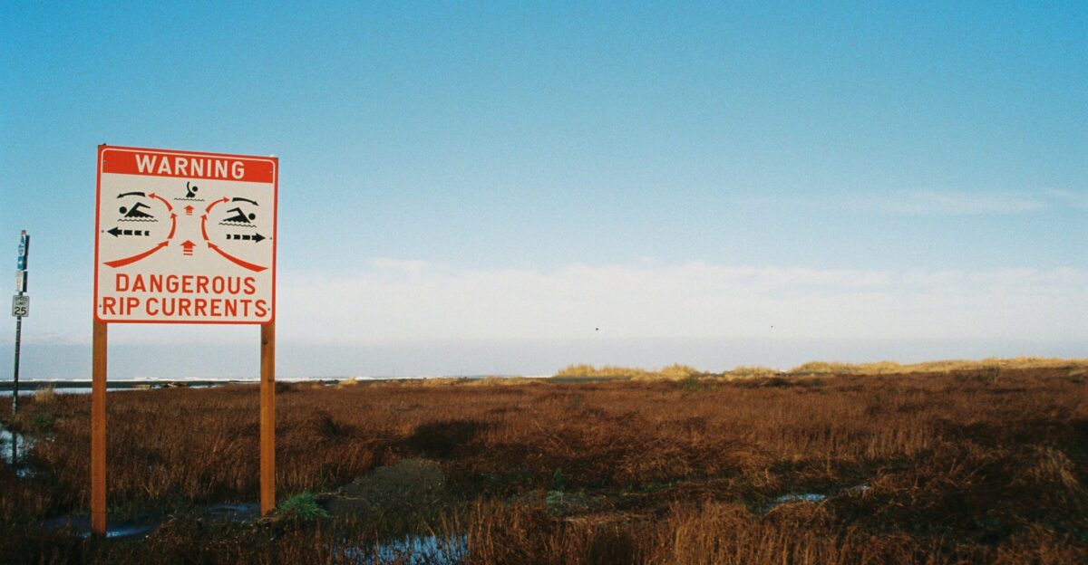 a red and white sign sitting on the side of a road