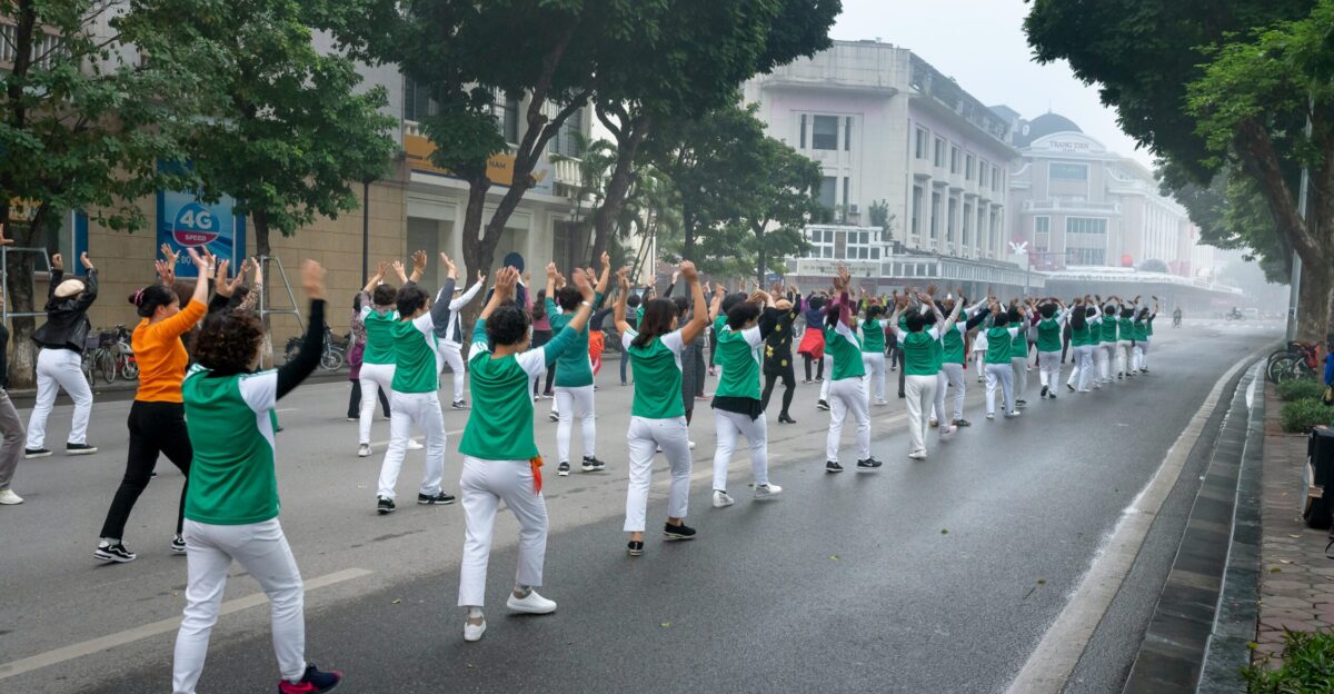 a group of people in green and white outfits marching down a street