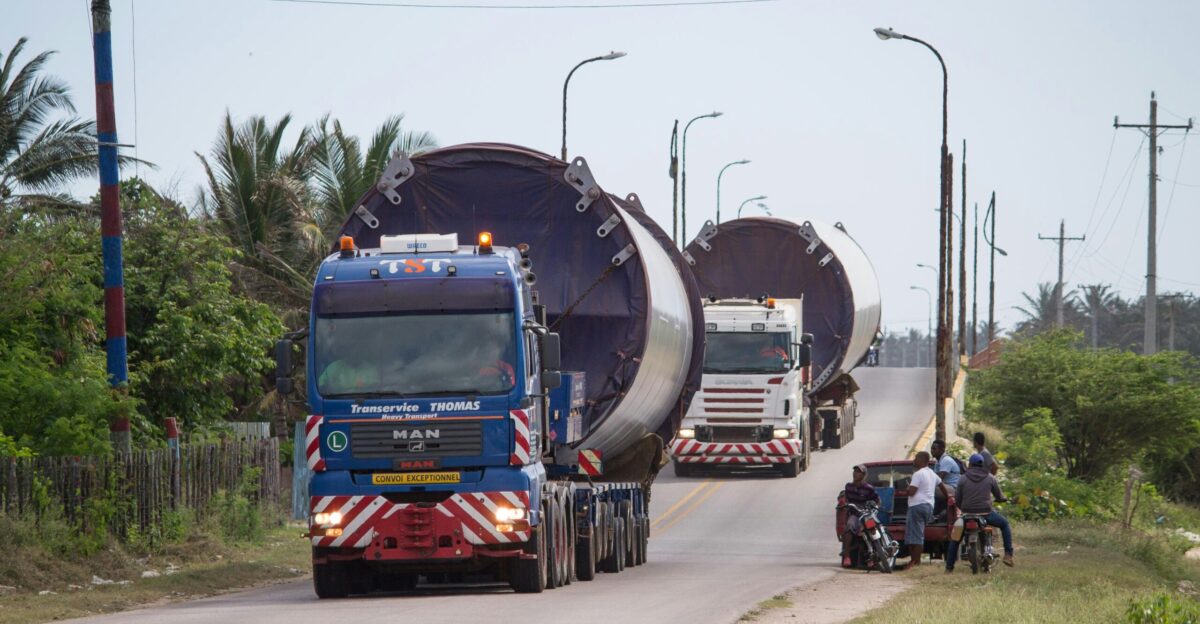 a couple of large trucks driving down a road