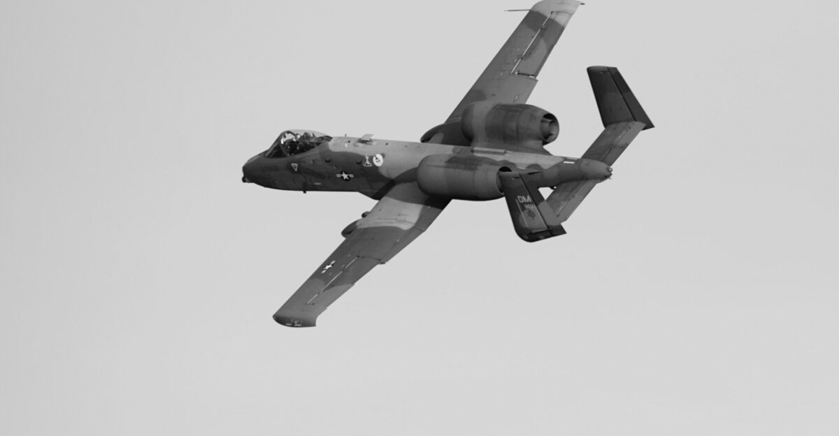 a military plane flying in the sky on a clear day