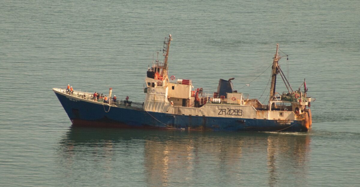 a blue and white boat floating on top of a body of water