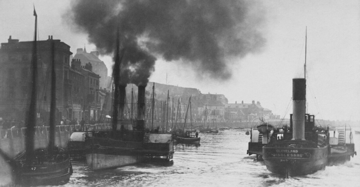 a black and white photo of a harbor filled with boats