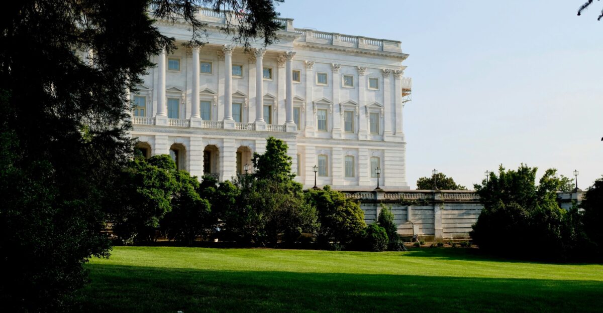 a large white building with trees in front of it