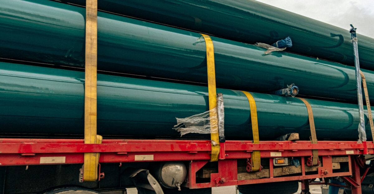 a large truck with a bunch of green pipes on the back of it
