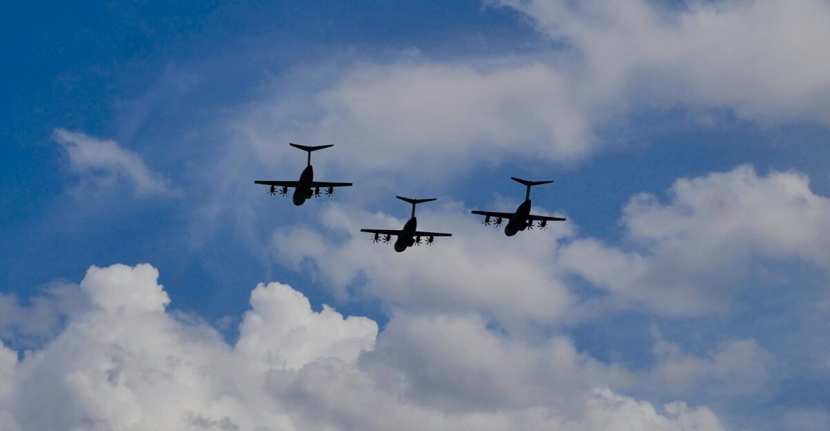 a group of three airplanes flying through a cloudy sky