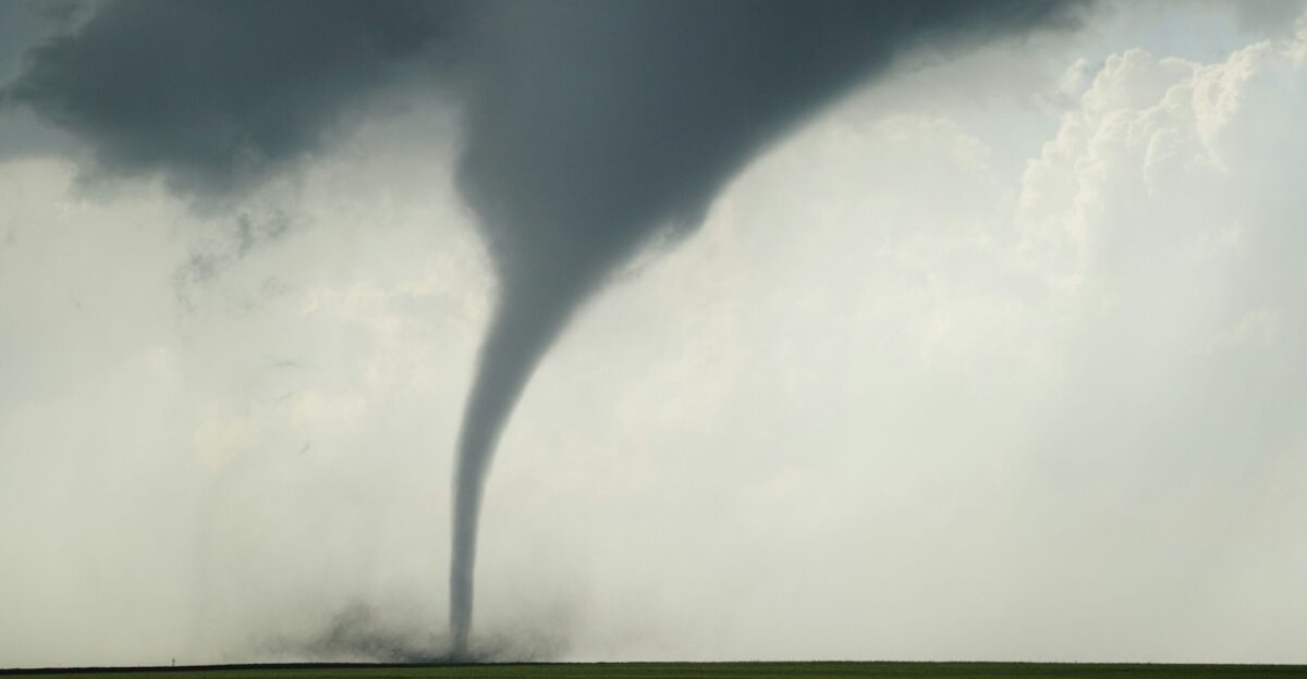 a large tornado is seen in the sky over a green field