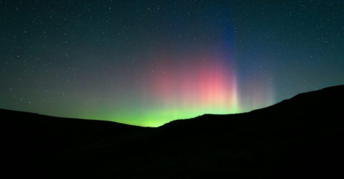 a bright green and red aurora bore in the night sky
