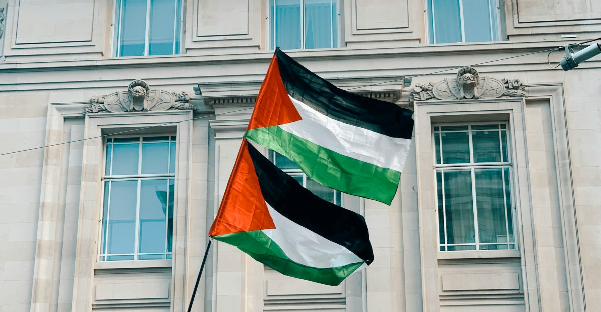 a flag flying in front of a tall building