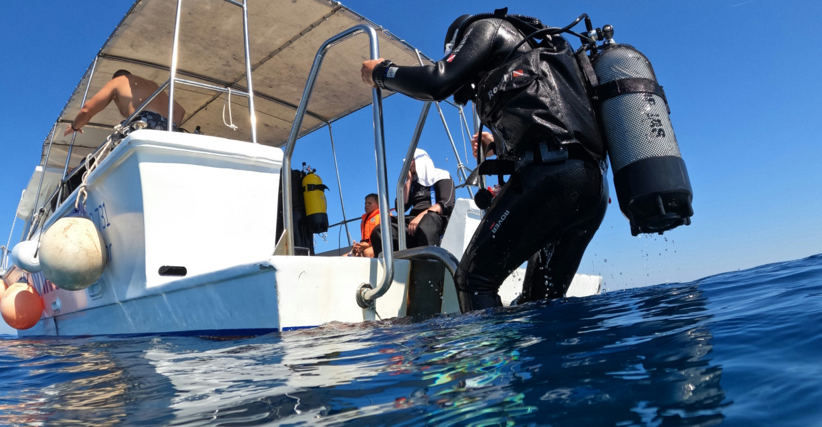 a man in a wet suit is on a boat in the water