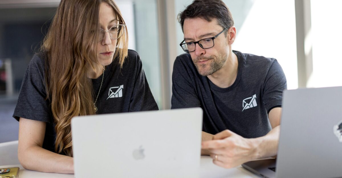 a man and a woman looking at a laptop