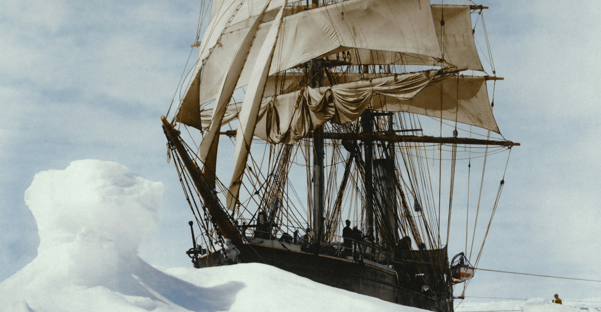 a large white sail boat floating on top of snow covered ground