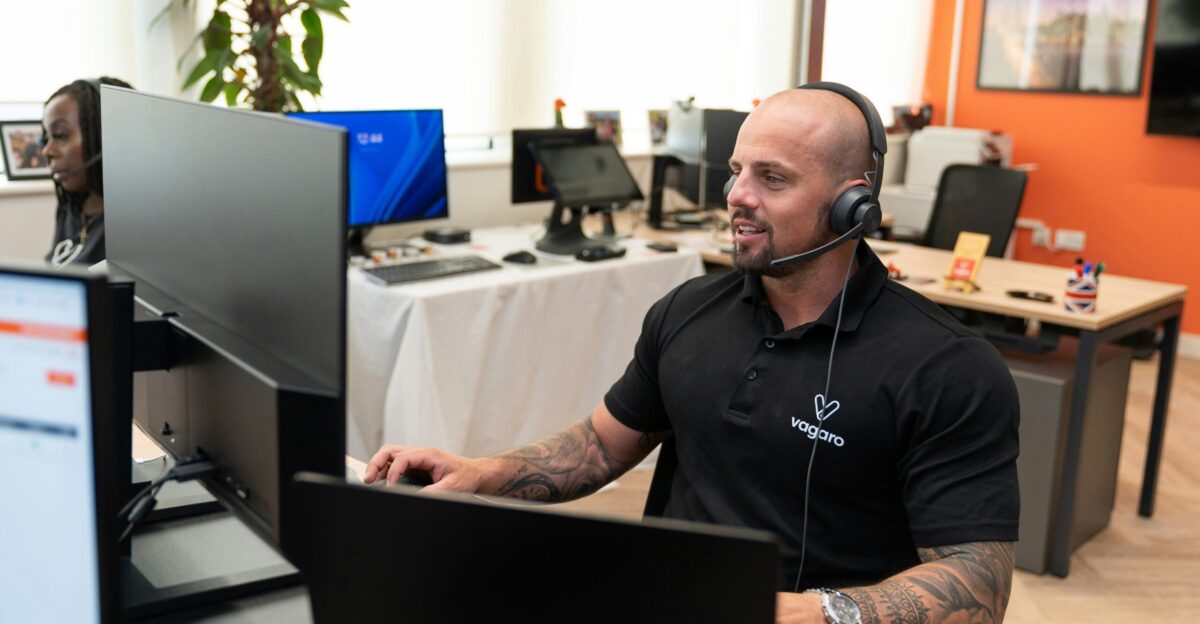 a man wearing a headset sitting in front of a computer