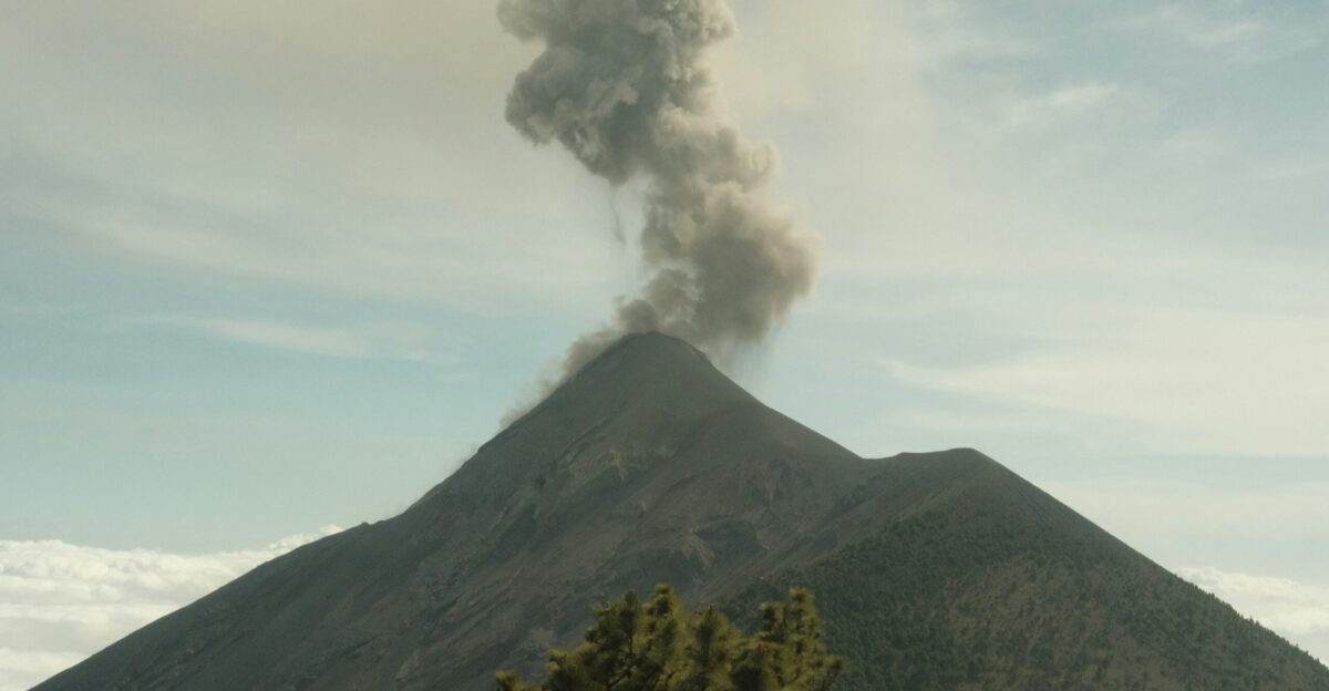 a large plume of smoke rising from the top of a mountain