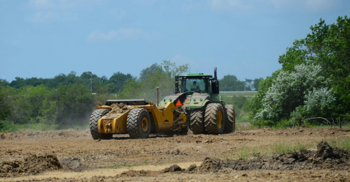 a tractor is plowing a field of dirt