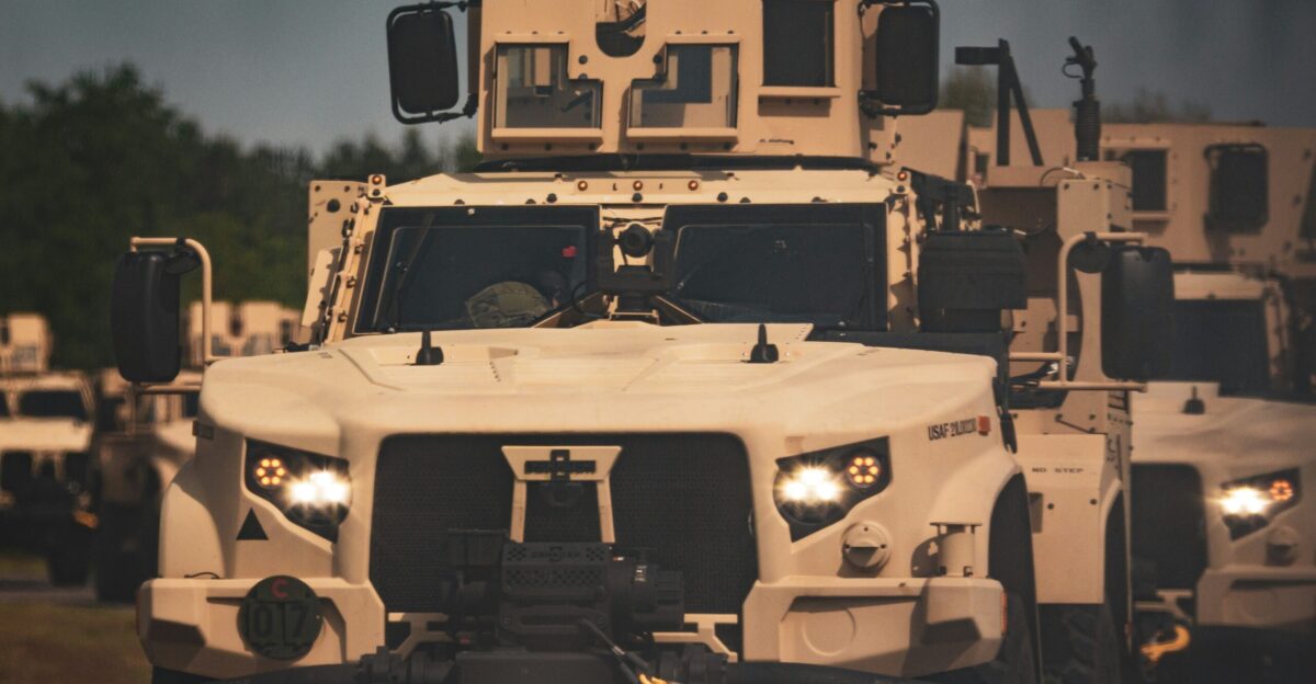 A group of military vehicles driving down a road